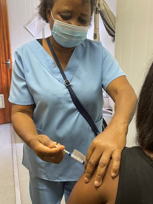 Lilian Twentiey, a CIDRI-Africa team member, injects the first MESA-TB study participant.