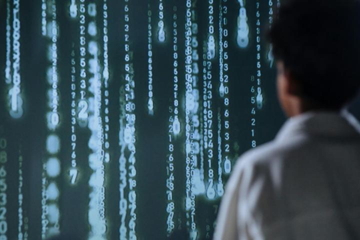 A woman in a white coat staring at floating numbers infront of her