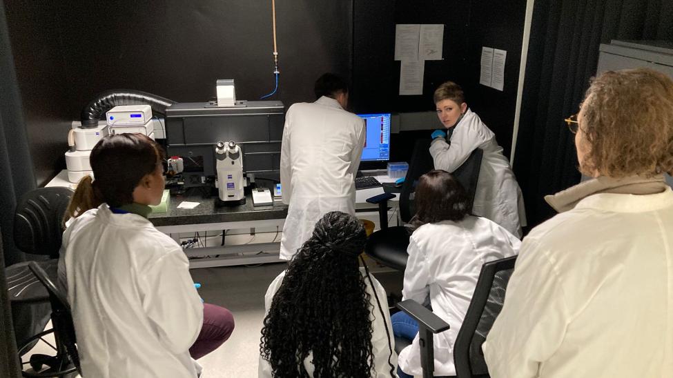 Workshop participants next to a widefield microscope
