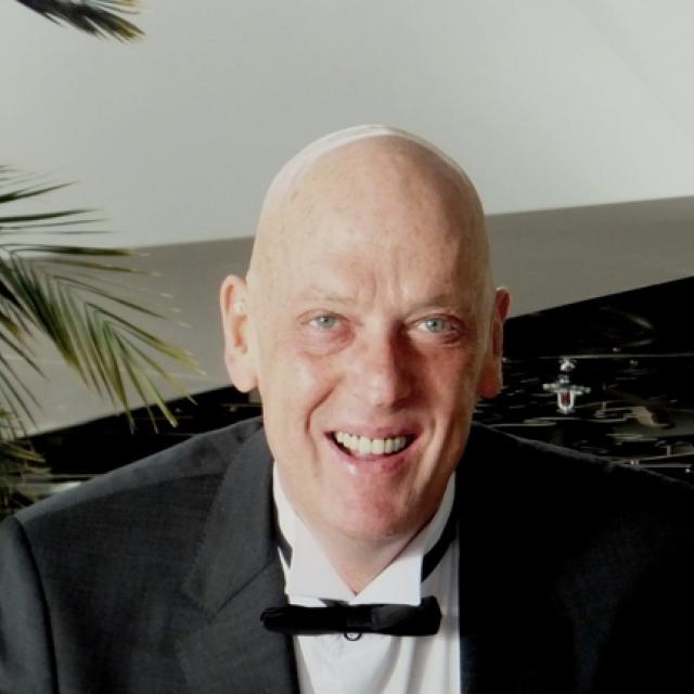 A head-and-shoulders photo of Prof. Adrian Brink. He is wearing a tuxedo