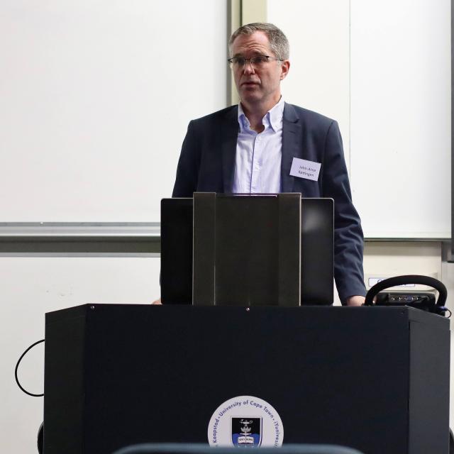 John-Arn Rottingen standing at a lectern