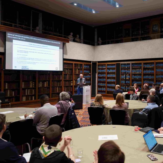 Prof. Robert J Wilkinson presenting to an audience in a library