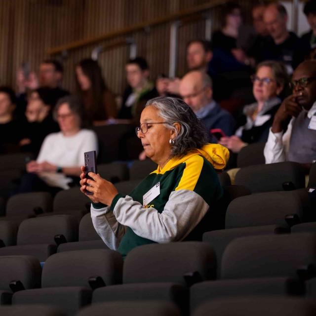 Meeting participants use their mobile phones to read a QR code displayed off-screen