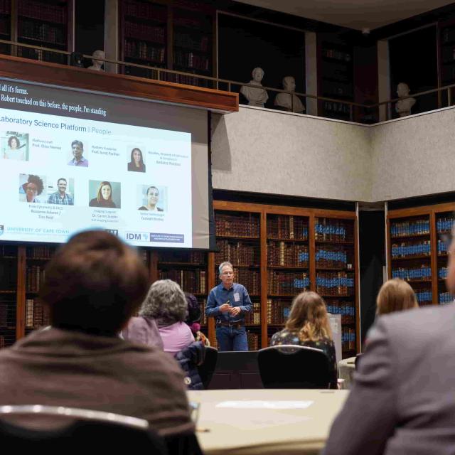 Prof. Digby Warner presents the laboratory science platform to an audience in a library