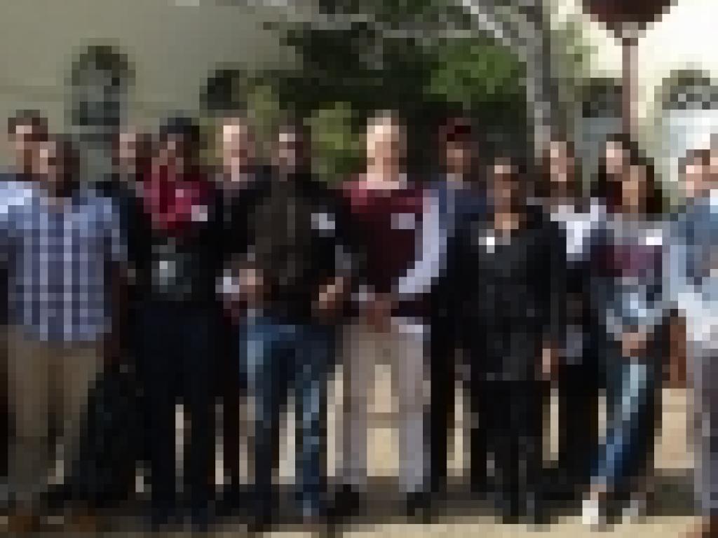 A group of workshop attendees stand in the plaza of the Faculty of Health Sciences