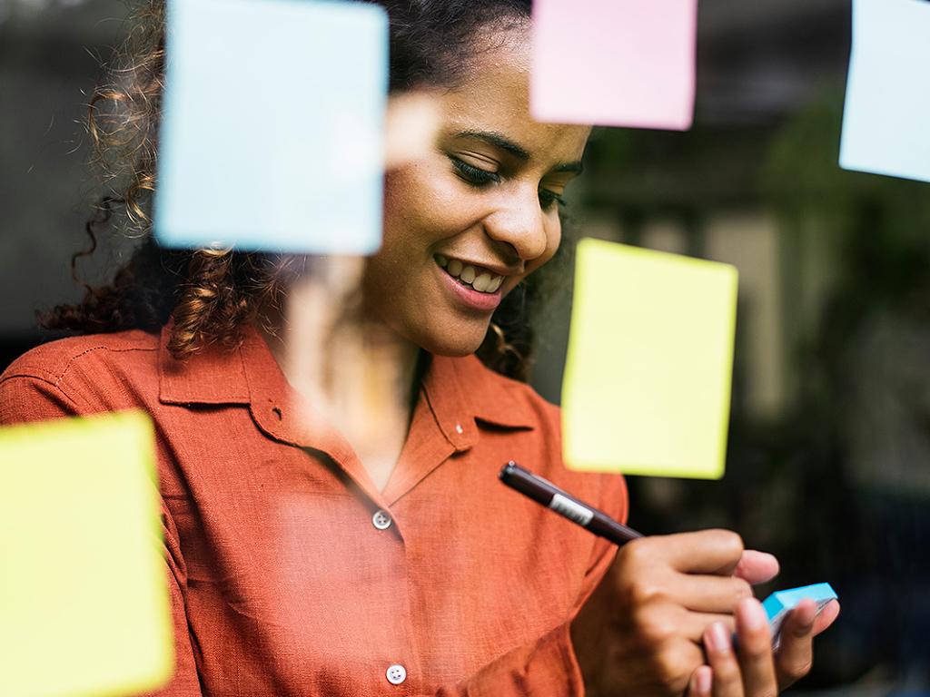 Person standing behind glass wall with sticky notes